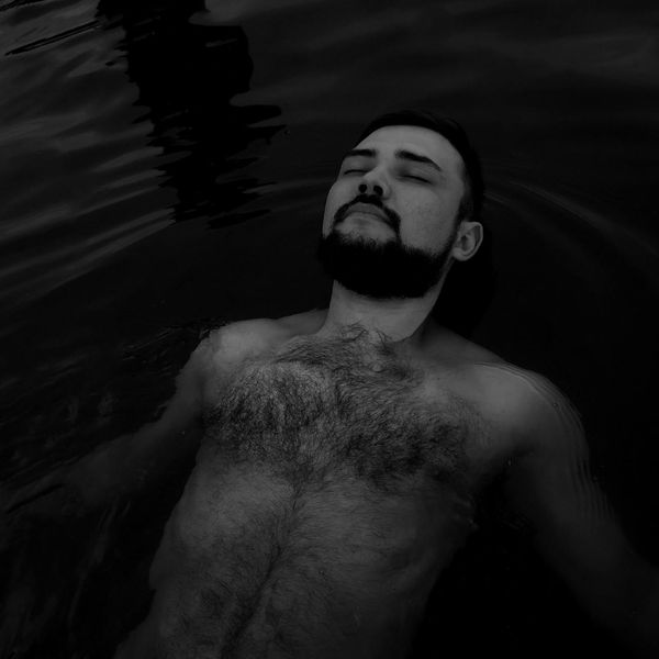 Person meditating peacefully outdoors with a natural background.